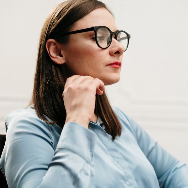 Woman practicing mindful breathing in a calm, modern office setting.